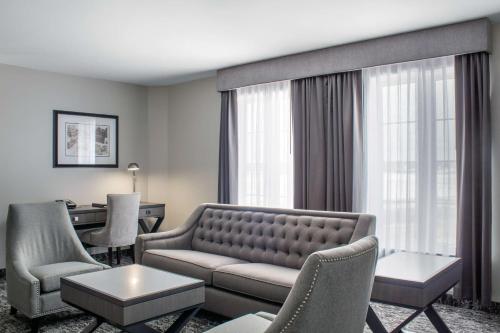 a living room with a couch and chairs at Chateau Moncton Trademark Collection by Wyndham in Moncton