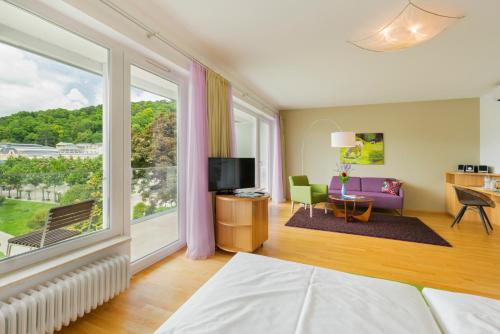 a bedroom with a bed and a large window at At the Park Hotel in Baden