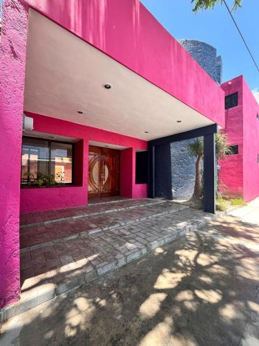 a pink building with a door in the middle at Mi Casa in Progreso