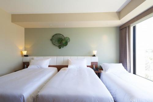 two beds in a room with a window at Hyatt Regency Naha, Okinawa in Naha