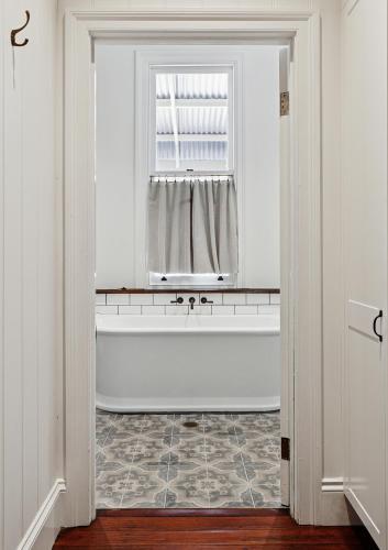 a white bathroom with a tub and a window at Argyle Hotel, Maclean in Maclean