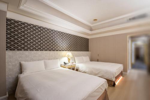 a hotel room with two beds and a wall at Ohotel in Taichung