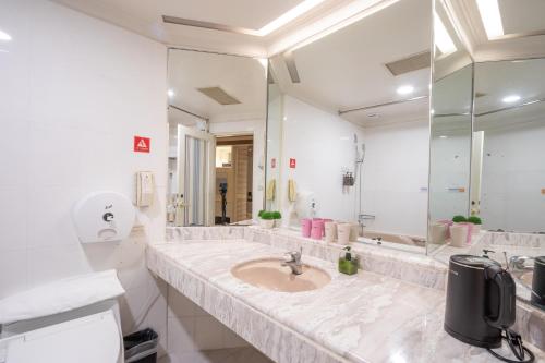 a bathroom with a sink and a large mirror at Ohotel in Taichung