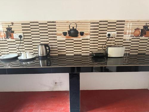 a counter with pots and pans on a wall at J Rest in in Trincomalee