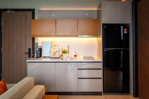 a kitchen with a black refrigerator and a sink at Antara Genting by Harvinton Mansion in Genting Highlands