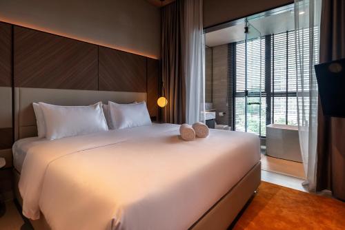 a bedroom with a large white bed and a window at Antara Genting by Harvinton Mansion in Genting Highlands