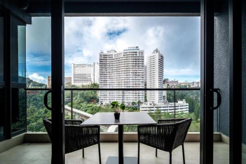 a table and two chairs in front of a window at Antara Genting by Harvinton Mansion in Genting Highlands