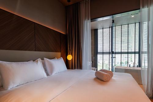 a bedroom with a large white bed with a large window at Antara Genting by Harvinton Mansion in Genting Highlands