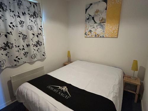 ein Schlafzimmer mit einem Bett mit einer schwarzen und weißen Decke in der Unterkunft Appartement Sud avec Terrasse et Garage à Super Besse - FR-1-814-96 in Besse-et-Saint-Anastaise