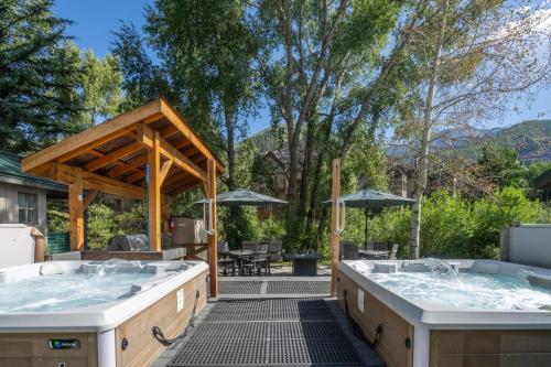 two hot tubs on a patio with a table at Mountainside Inn 314 by Alpine Lodging Telluride in Telluride