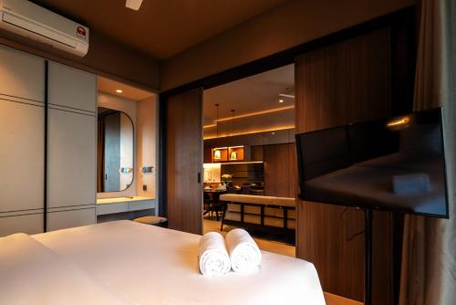 a bedroom with a bed with two white shoes on it at Antara Genting by Harvinton Mansion in Genting Highlands