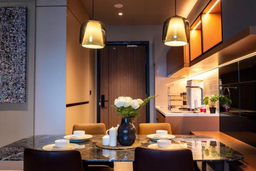 a dining room table with chairs and a vase of flowers at Antara Genting by Harvinton Mansion in Genting Highlands