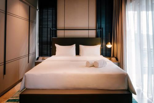 a bedroom with a large white bed with towels on it at Antara Genting by Harvinton Mansion in Genting Highlands