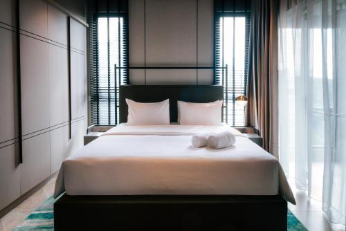 a bedroom with a large bed with two towels on it at Antara Genting by Harvinton Mansion in Genting Highlands