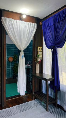 a room with a shower with a curtain and a table at Sukhothai City Resort in Sukhothai