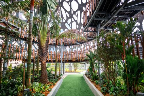 an indoor garden with palm trees and plants at Antara Genting by Harvinton Mansion in Genting Highlands