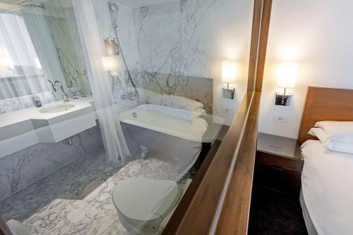 a bathroom with a shower and a toilet and a sink at United Hotel in Taipei