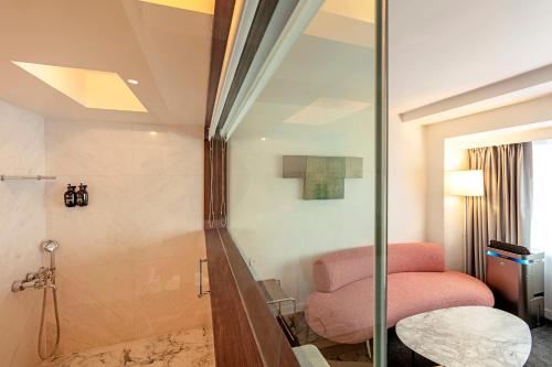 a bathroom with a shower and a pink chair at United Hotel in Taipei