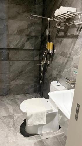 a bathroom with a white toilet and a sink at Vibe Hotel Alabang in Manila