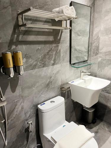 a bathroom with a white toilet and a sink at Vibe Hotel Alabang in Manila