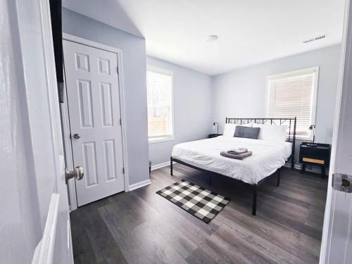 a white bedroom with a bed and a window at 5 Min to Elon - In Unit Washer and Dryer - Fast Wi-Fi in Burlington