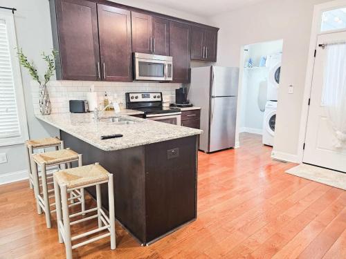 a kitchen with a large island in a kitchen with wooden floors at Fire Pit - 4 Min from UNC - 7 Min from Carrboro - Fast Wi-Fi in Chapel Hill