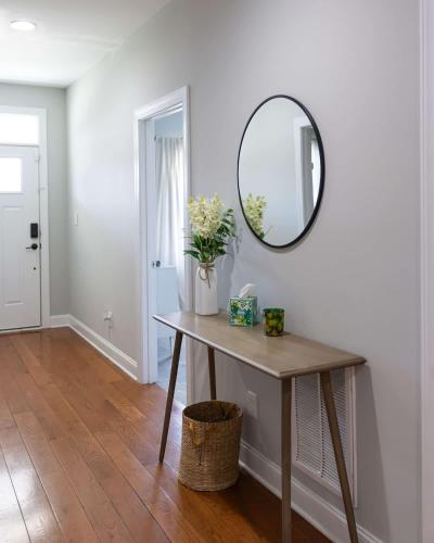 a mirror on a wall above a table with flowers at 4 Minutes to UNC - 7 Minutes to Carrboro - En-Suite Bathrooms in Chapel Hill