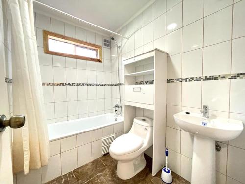un bagno bianco con un water e un lavandino di ApartHotel Cuatro Estaciones Frutillar Bajo a Frutillar