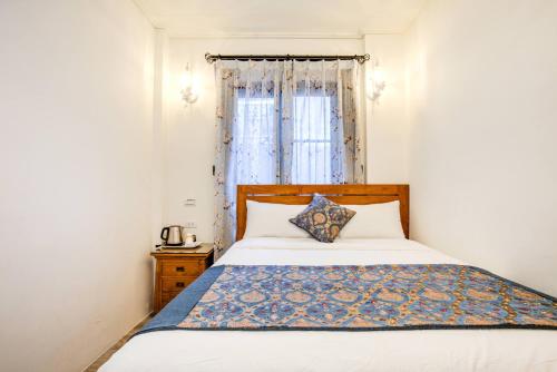 a bedroom with a white bed with a window at 小琉球白沙逗琉民宿 浮潛生 態導覽 包棟推薦 in Xiaoliuqiu