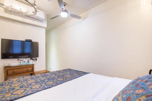 a bedroom with a bed and a flat screen tv at 小琉球白沙逗琉民宿 浮潛生 態導覽 包棟推薦 in Xiaoliuqiu