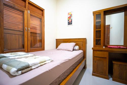 a small bedroom with a bed and a dresser at Bale Ayem Prambanan Homestay Jogja in Bugisan