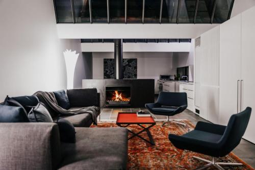 a living room with a couch and a fireplace at Alkina Lodge Namu in Wattle Hill