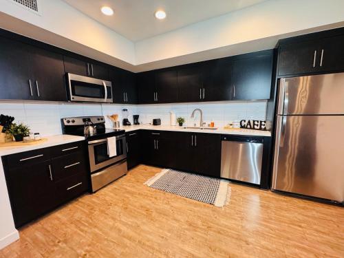 a kitchen with black cabinets and stainless steel appliances at The Hollywood loft FREE Parking in Los Angeles