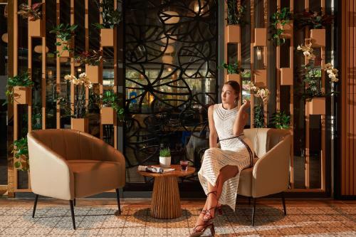 a woman sitting in a chair in a room at Hoi An Royal Beachfront Villas in Dien Ban