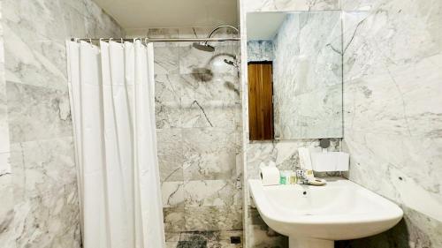 een witte badkamer met een wastafel en een douche bij Cozy condo maikhao Phuket in Ban Mai Salae