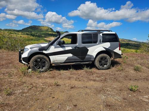 a white and black truck parked in a field at Maison d ampasikely in Nosy Be