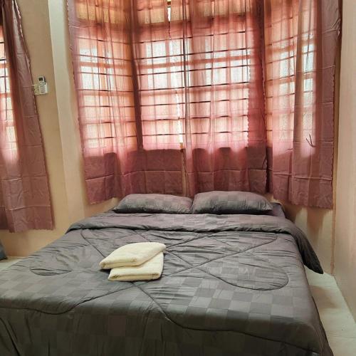a bed with two towels on top of it at CYC homestay 18 pax in Kampong Batu Lapan