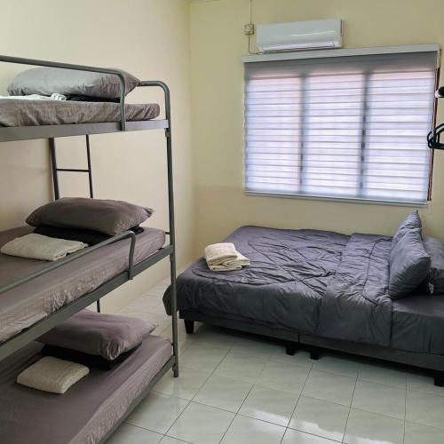 a bedroom with two bunk beds and a window at CYC homestay 18 pax in Kampong Batu Lapan
