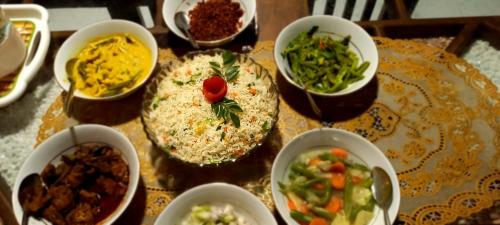 アヌラーダプラにあるMandara Holiday Homeのさまざまな種類の食べ物が入ったボウルが置かれたテーブル