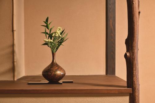 a vase sitting on a shelf in front of a mirror at Oni no Sumika in Izu