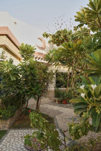 a building with trees in front of a courtyard at Emirati Stay Comfort & Local Charm Villas - 3 in Dubai