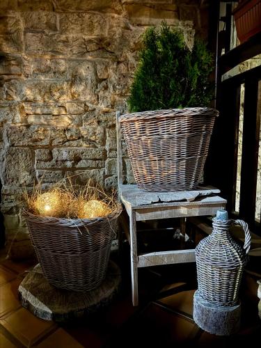 two baskets sitting on a chair next to a stone wall at Stenata LightWill in Banya