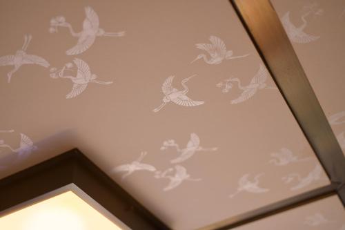 a ceiling with birds stenciled on a wall at Oni no Sumika in Izu