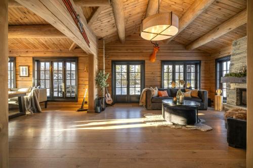 a living room with a wooden ceiling and a fireplace at Neighbour Cabins For Groups At Vegglifjell in Veggli