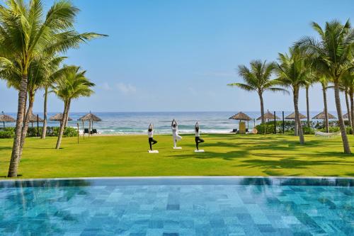 a group of people doing yoga by the beach at Hoi An Royal Beachfront Villas in Dien Ban