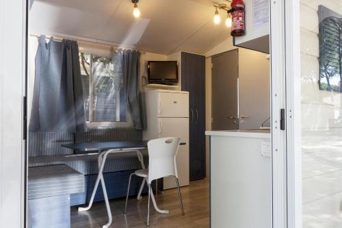 a kitchen and dining area of a tiny house at Camping Village Cavallino in Cavallino-Treporti