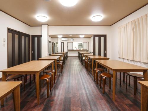 a row of tables and chairs in a room at Onsenminshuku Kosakaya in Nachikatsuura