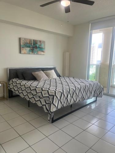 a bed in a bedroom with a ceiling fan at Enjoy an endless summer - Parking included! in Sunny Isles Beach