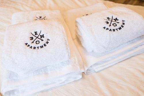 dos toallas sentadas encima de una cama en 3EM Apartment Sopot en Sopot