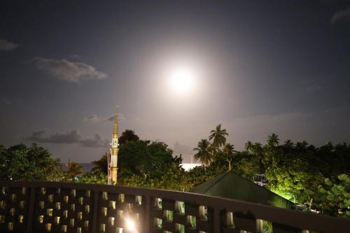 a clock tower with the moon in the sky at Pamera Thoddoo in Thoddoo